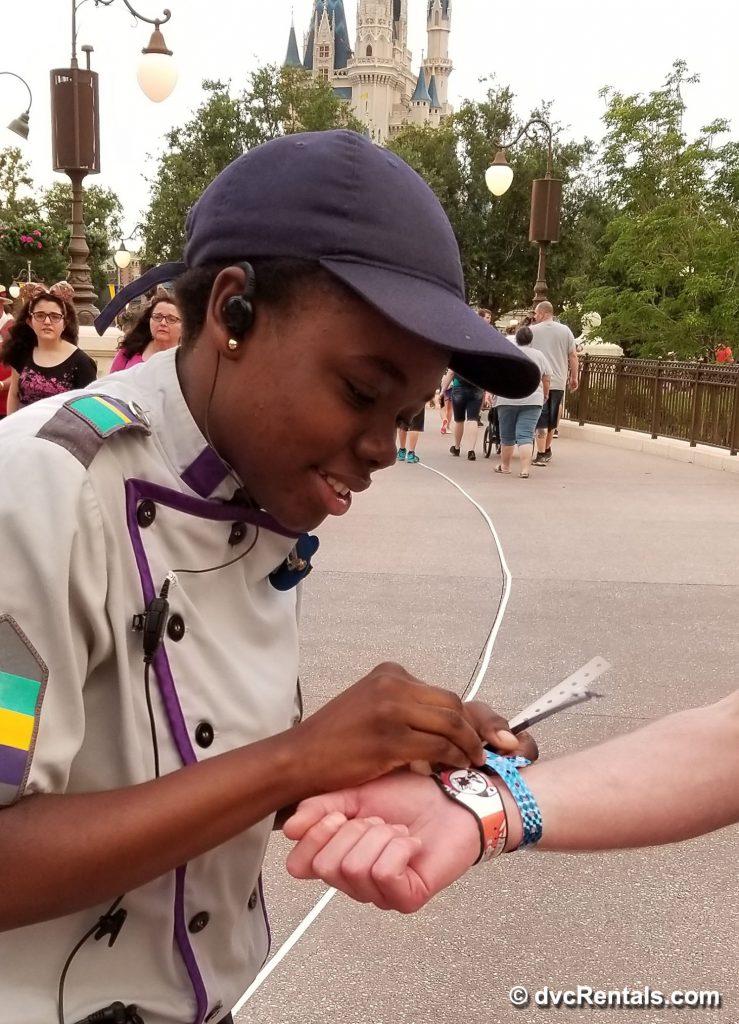 Cast Member placing party wristband on a team member’s arm