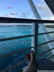 team member Stacy sitting and relaxing with her feet up on her verandah on the Disney Dream