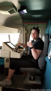 Team Member Darcy sitting in the drivers chair of a WDW monorail