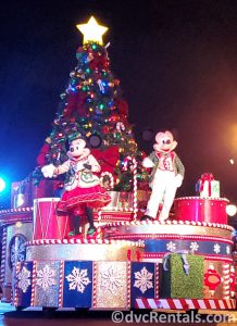 Mickey and Minnie in Christmas attire waving to guests