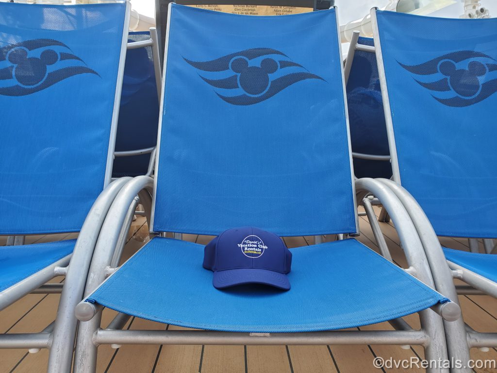Disney Cruise Line lounge chairs with a David’s Vacation Club Rentals hat