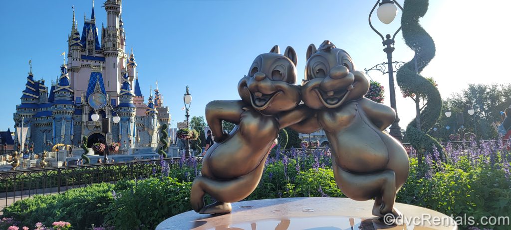 Chip and Dale gold statues with Cinderella Castle in the background at the Magic Kingdom