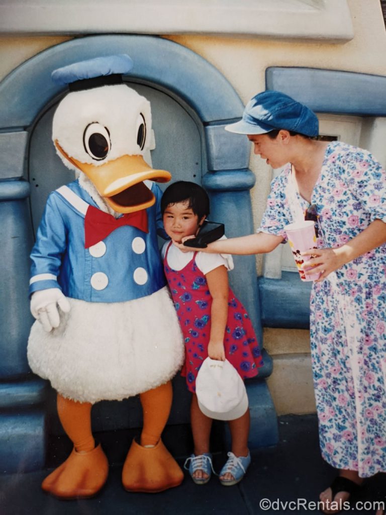 Team Member Ashley as a child hugging Donald Duck