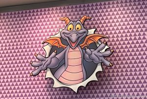 A graphic where it looks like Figment is bursting through a purple wall.