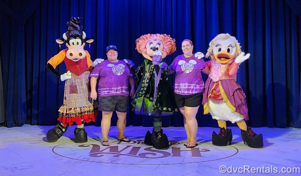 A photo of team members Lindsay and Stacy with Minnie Mouse, Daisy Duck, and Clarabelle Cow as the Sanderson Sisters