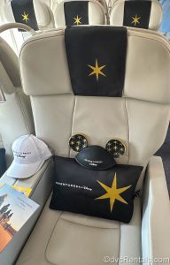 Adventures by Disney branded Pillow, Mickey Ears, and Ball Cap all sitting on a Private Jet Seat