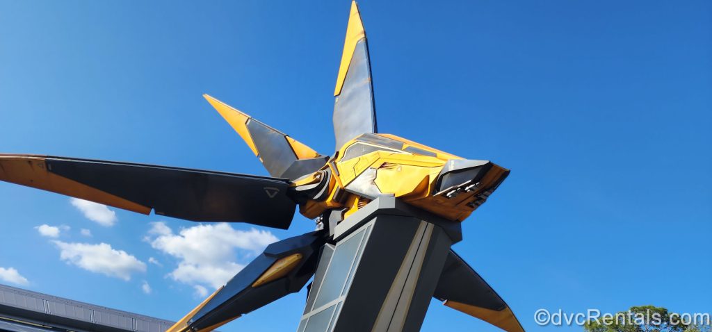 Large statue of yellow and gray spaceship outside of the Guardians of the Galaxy ride.