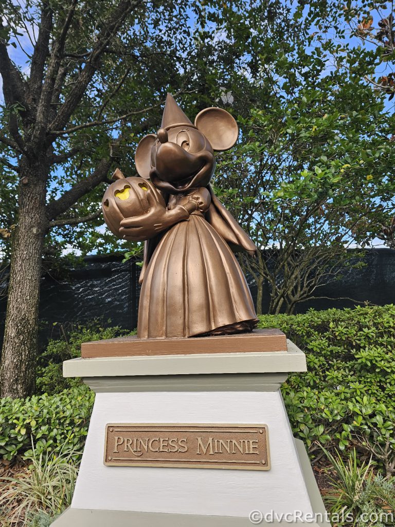 Golden Statue of Minnie dressed up like a Princess holding a pumpkin.