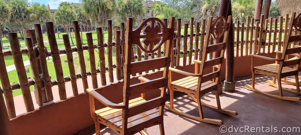 Brown wooden rocking chairs on a porch overlooking the Savanna.