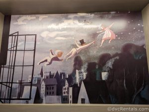 Mural of Wendy, Michael, John, and Peter Pan flying through the night sky.