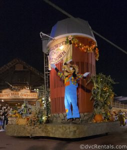 Farmer Goofy standing on a float with a silo and a sign that reads "Halloween Hoedown."