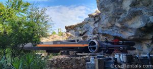 Black and Orange Spaceship nestled between rocks and trees in Galaxy's Edge at Hollywood Studios.