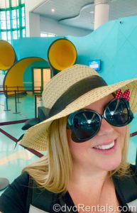 Stacy wearing a sun hat in front of the entrance onto the Disney Dream Cruise Ship.