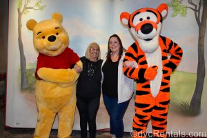 Stacy and her mom posing with Winnie the Pooh and Tigger.