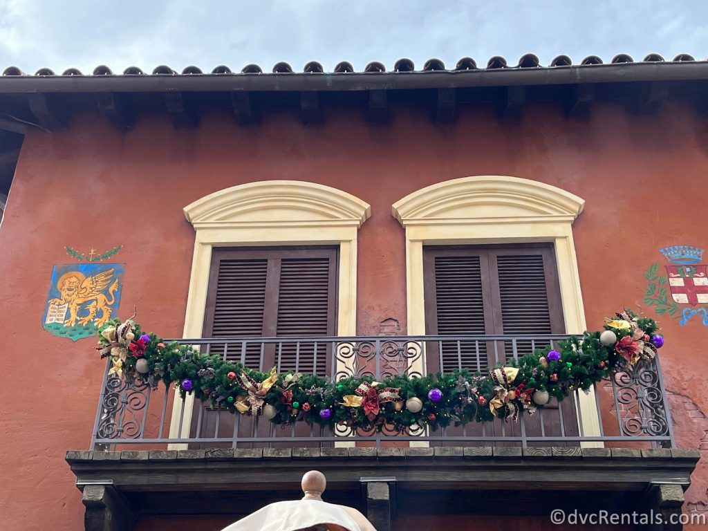 Garland and ornaments hanging from a rod-iron balcony in the Italy Pavilion.