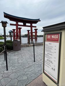 Shi Wasu Festival booth menu sign with the Japanese Torii Gate in the background.