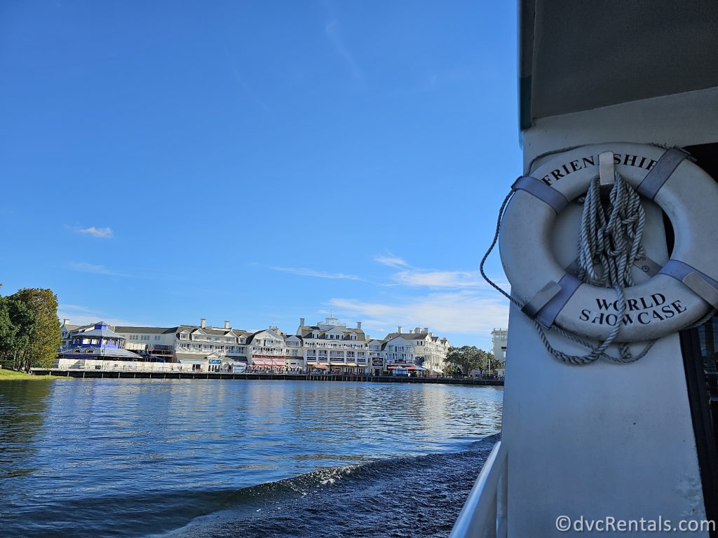 White Life Buoy hanging on the side of a boat with Disney's Boardwalk in the horizon.