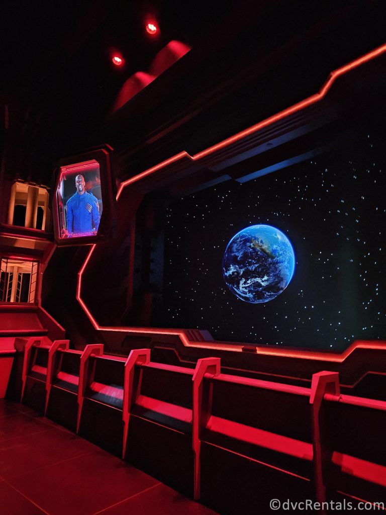 Screens in the queue of Guardians of the Galaxy, one showing Earth and one showing Terry Crews.
