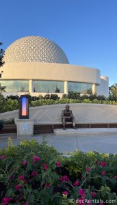 New Walt Disney Statue sitting in front of a stone wall with Spaceship Earth in the background.