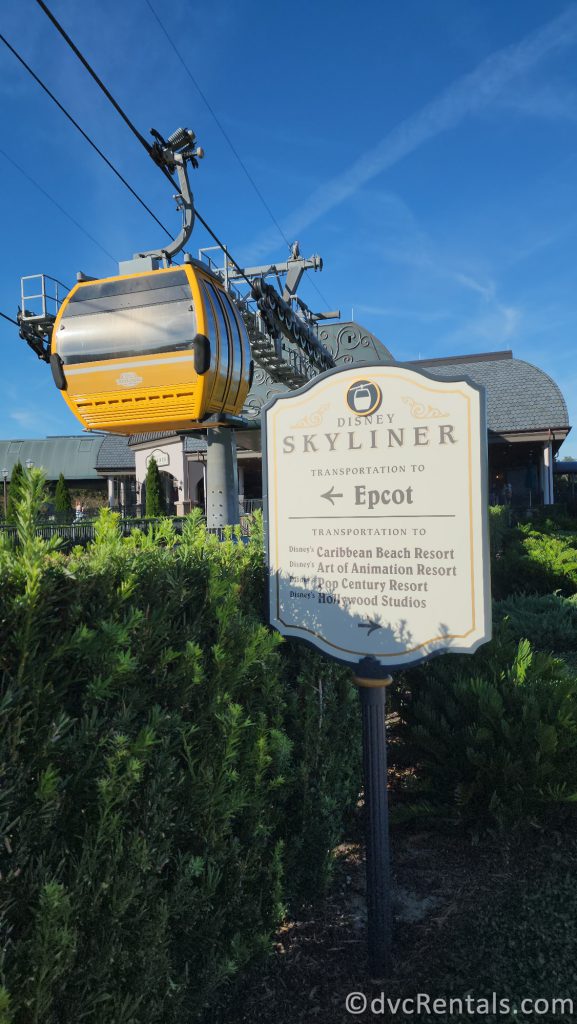 Disney Skyliner Sign pointing towards Epcot with a yellow gondola getting ready to take off.
