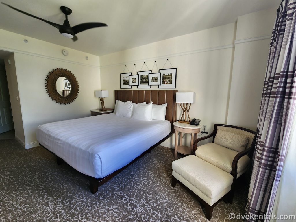 King-Sized Bed and Arm Chair in the One Bedroom Villa's Main Bedroom at Disney's Saratoga Springs Resort and Spa.