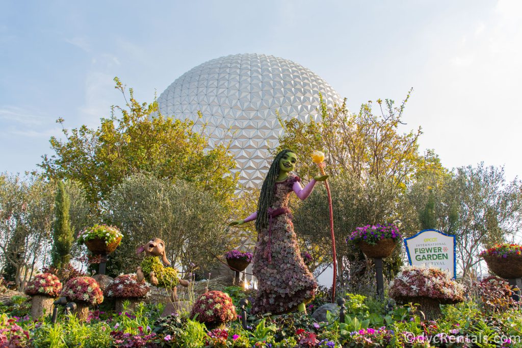 Topiary of Asha, Valentino, and the Wishing star from Disney's Wish in front of EPCOT's Spaceship Earth.