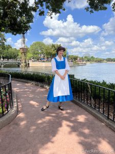Belle in her blue dress standing in front of World Showcase Lagoon.