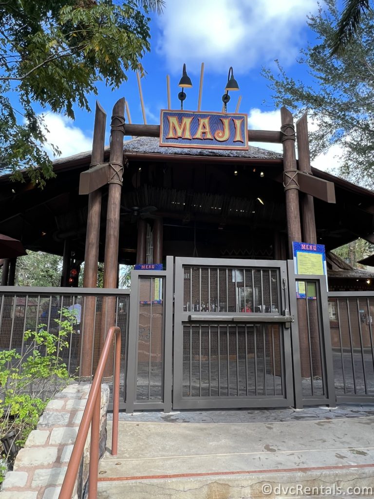 Exterior of Maji Pool Bar at Disney's Animal Kingdom Villas, Kidani Village. The circular wooden building is surrounded by a metal fence.