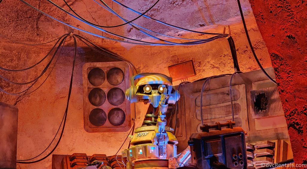 Animatronic DJ R-3X in Oga's Cantina. He is a small silver robot.