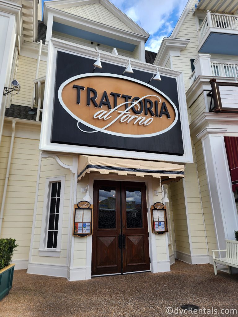 Exterior of Trattoria al Forno. The white building with a navy and gold sign that reads "Trattoria al Forno."