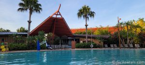 Oasis Pool at Disney's Polynesian Village Resort. There is a large orange iron awning next to the pool.