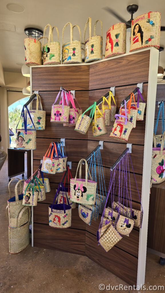 A wall housing many different woven bags featuring different Disney characters on them.