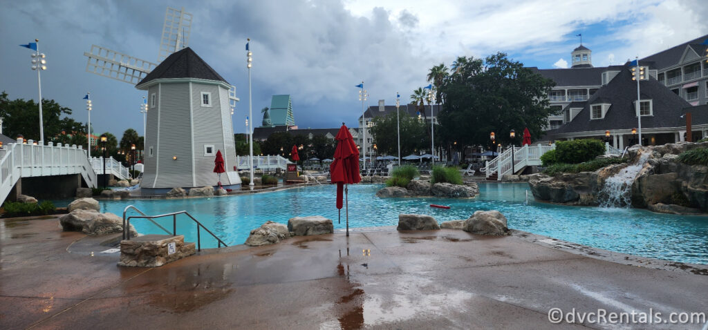 Pool at Disney's Beach Club Villas with a large white windmill and bridge in the middle of the pool.