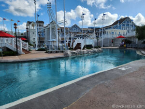 Pool at Disney's Beach Club Resort with the bright blue resort building in the background.