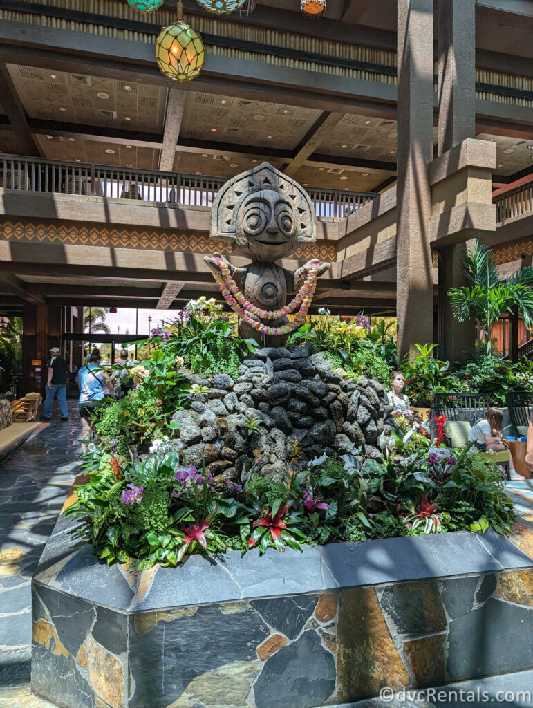 Tiki Statue standing atop a garden in the middle of the lobby at Disney's Polynesian Villas.