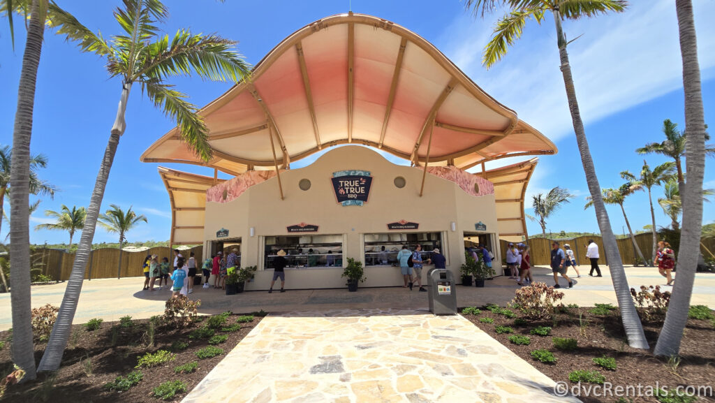 Exterior of True True BBQ. It is a beige shell-shaped building with a curved roof.