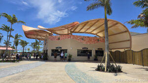 Exterior of True True BBQ. It is a beige shell-shaped building with a curved roof.