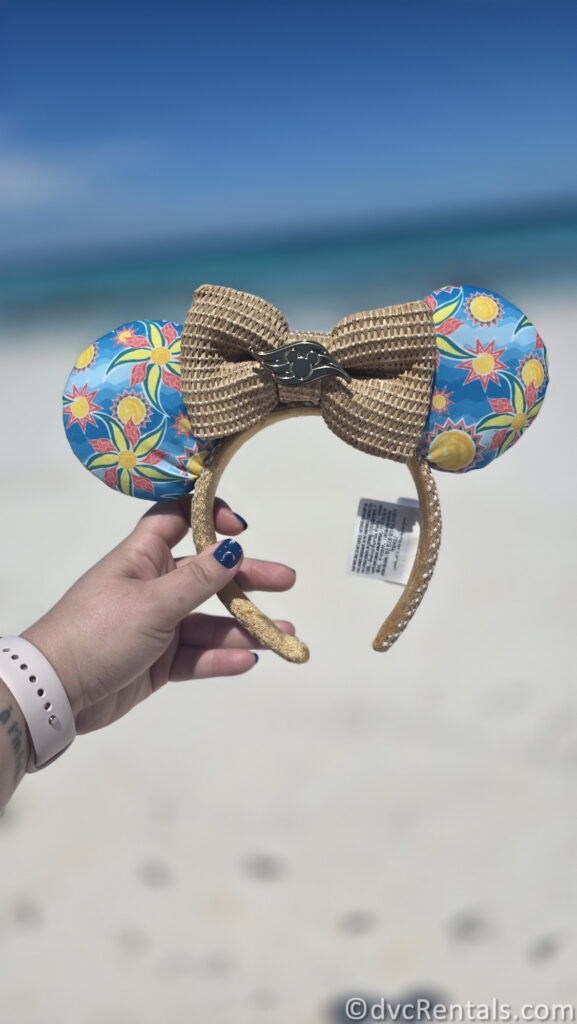 Disney Cruise Line Minnie Ears being held up in front of the Ocean.