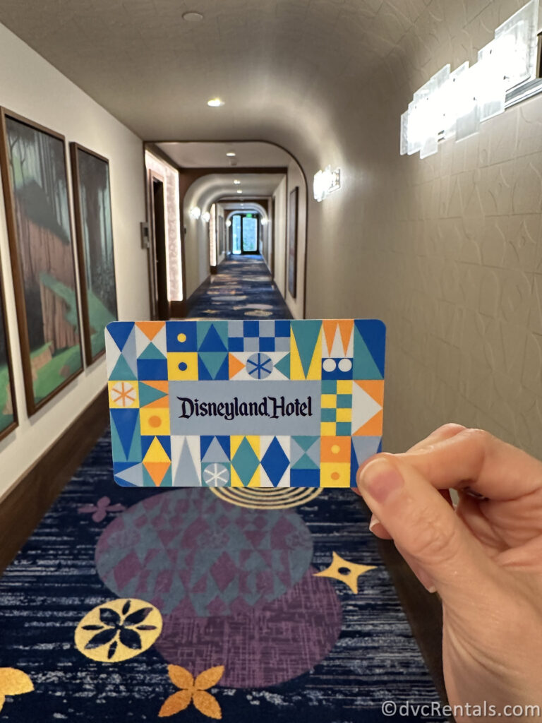 Hotel Card that reads "Disneyland Hotel" being held in a corridor of the hotel.