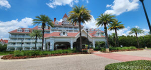 Exterior of Disney's Grand Floridian Resort and Spa. Large White Victorian-looking building with pink accents.