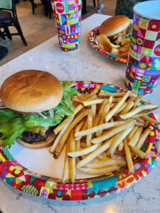 Cheeseburger and fries sitting on a table in Gasparilla Grill with a cup of soda in the background.