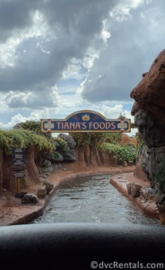 Sign in the ride that reads "Tiana's Foods" over the river on the ride.