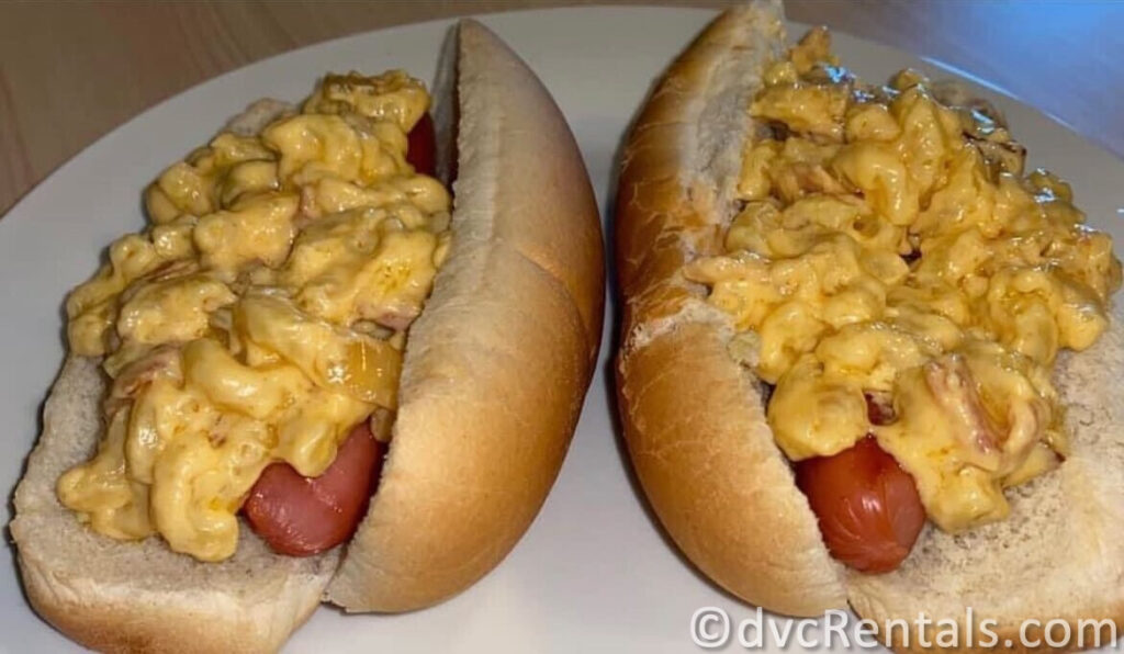 Two Hot Dogs covered in Macaroni and Cheese.