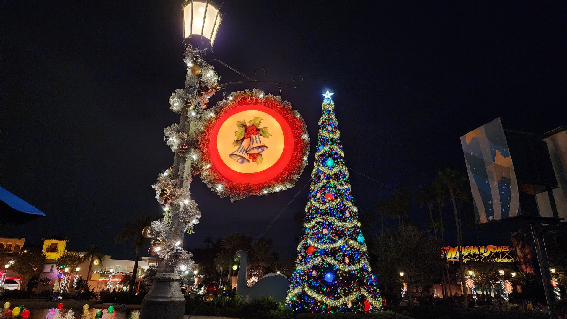 Large Christmas Tree in Echo Lake at Hollywood Studios lit up at night.