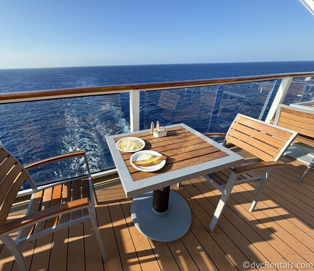 Pasta and Garlic Bread sitting on a wooden table in front of the ocean.