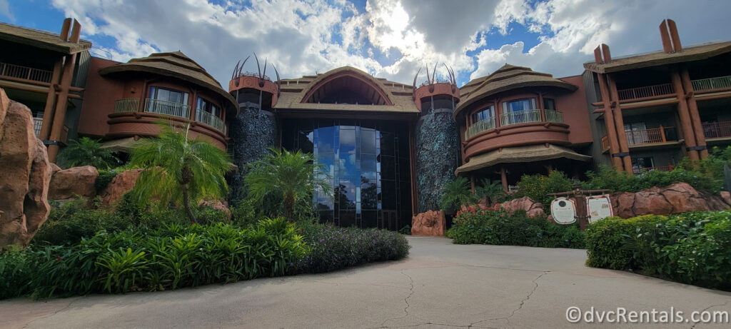 Entrance to Disney's Animal Kingdom Villas - Jambo House. The entrance features a large, glass-enclosed lobby with a waterfall on either side.