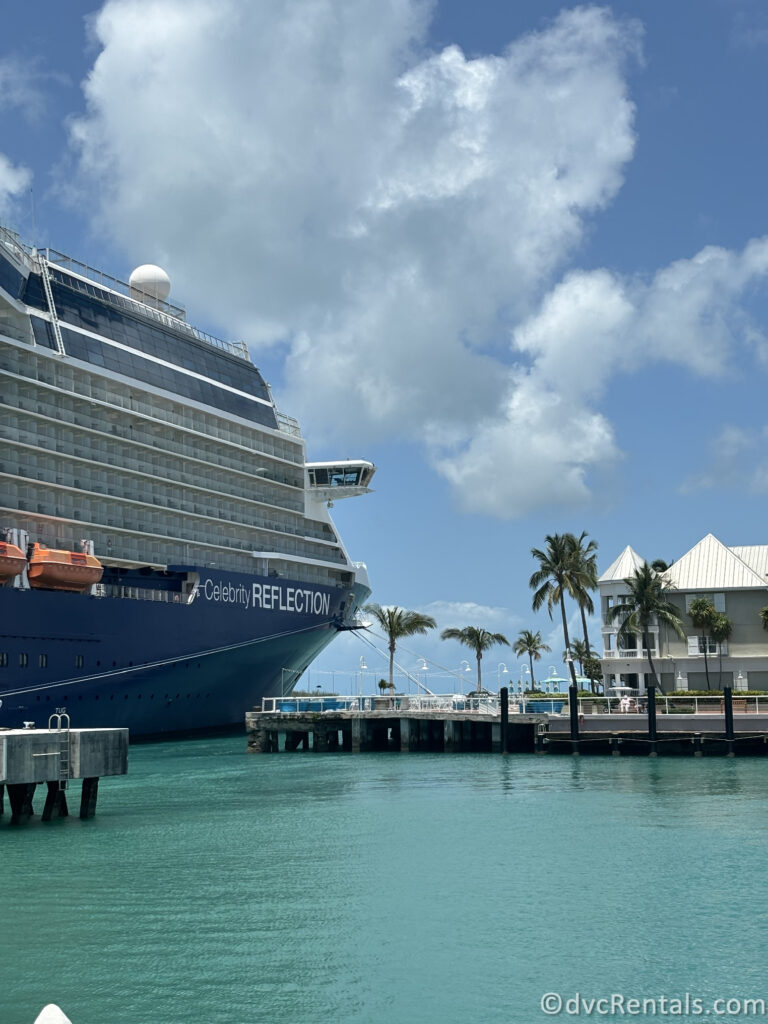 The Cruise Ship "Celebrity Reflection" docked in Key West with several lifeboats attached along its side. The ship is blue and white, with multiple balconies for guest cabins.