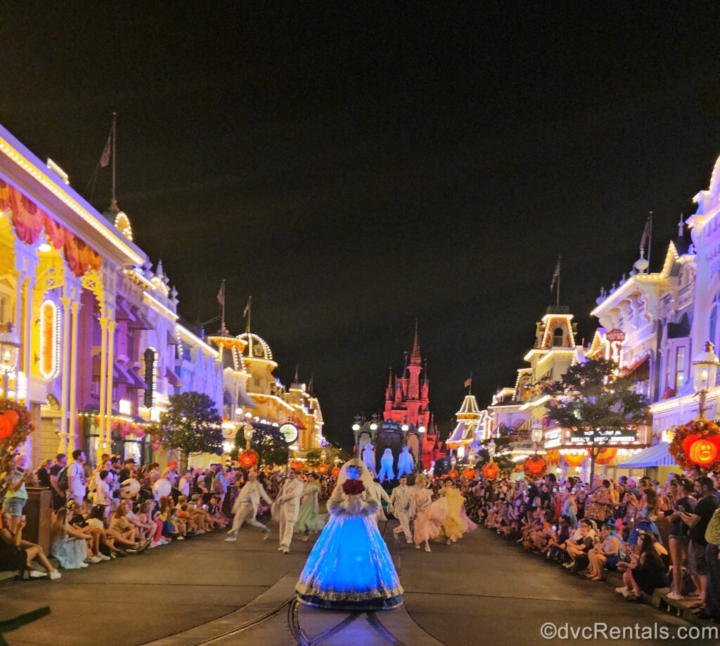 The Bride dressed in a white glowing gown from Haunted Mansion leads the way down the parade route with the ghostly dancers and hitchhiking ghosts following behind her down Main Street U.S.A.