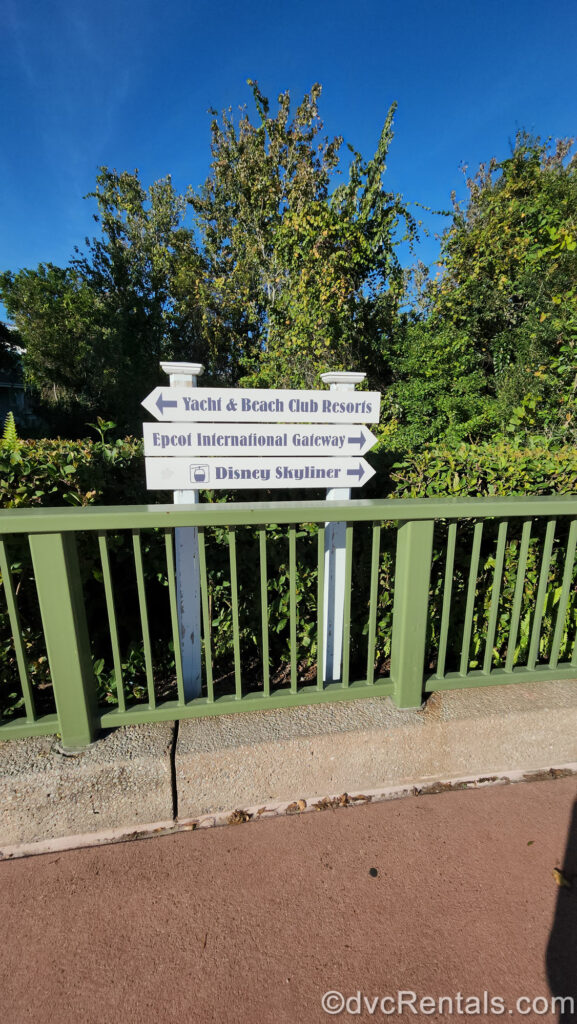 A white directional sign directs guests along the red-paved walkway between Disney’s BoardWalk Villas and other nearby destinations including Yacht & Beach Club Resorts, Epcot International Gateway, and a Disney Skyliner Station.