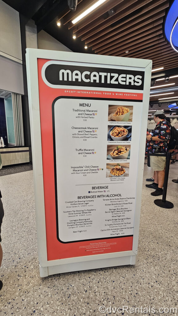 The red, white, and black menu board for the Macatizers booth. There are photos and descriptions of the different food and drink options, as well as pricing displayed on the menu board.